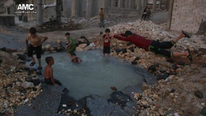 في سوريا، أطفال حلب يسبحون في برك خلفتها القنابل