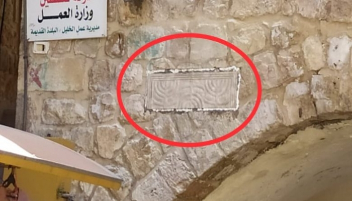 مستوطنون يثبتون حجرا يحمل كتابات عبرية في بالخليل
